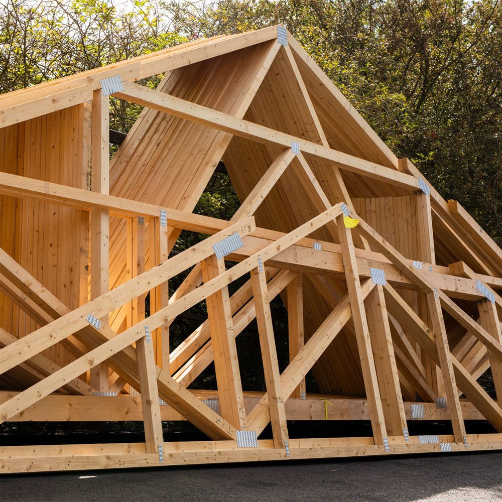 Timber roof trusses with MiTek connector plates, stacked on site